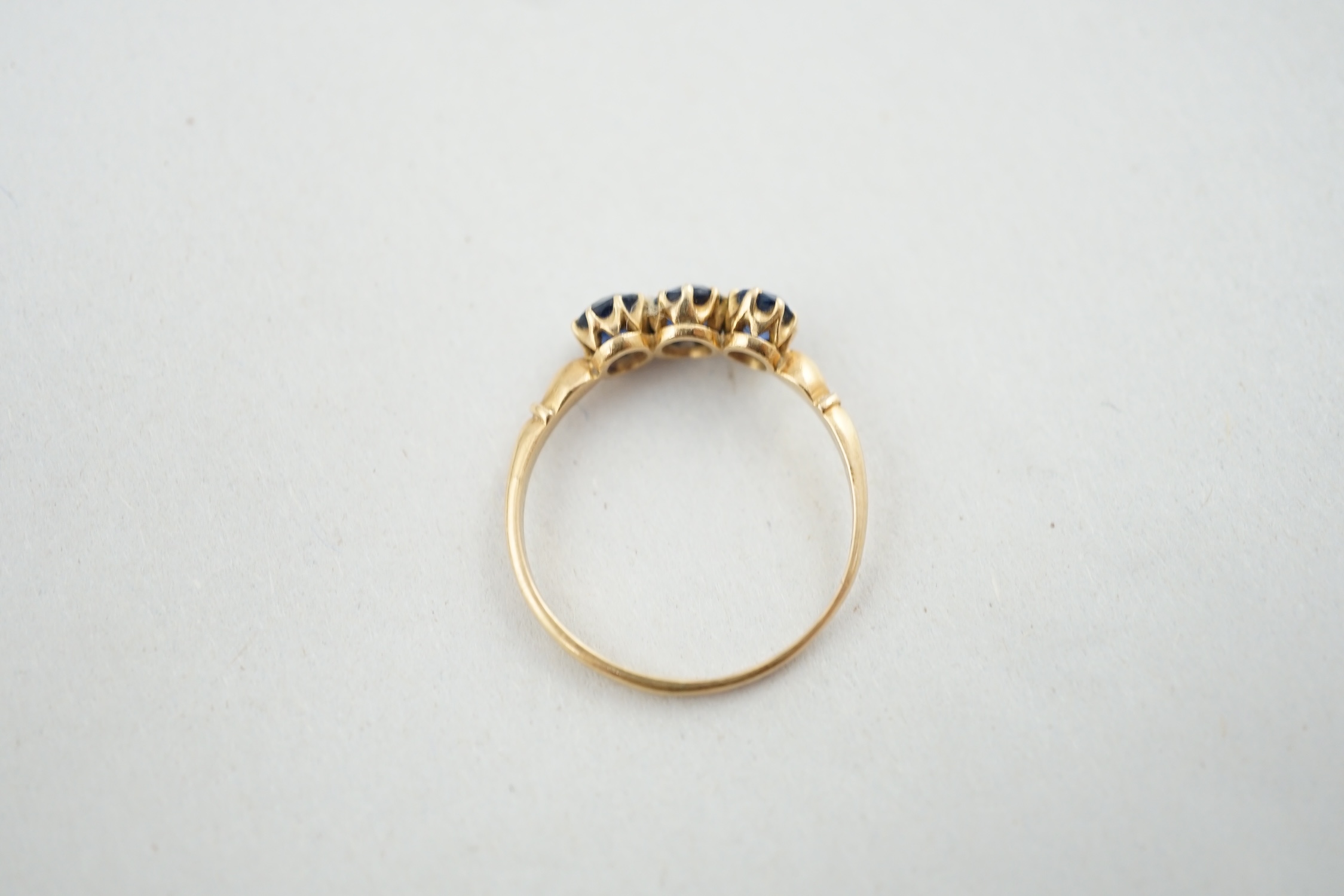 A late Victorian 18ct gold and three stone oval cut sapphire set ring, size P/Q, gross weight 1.9 grams. Condition - fair